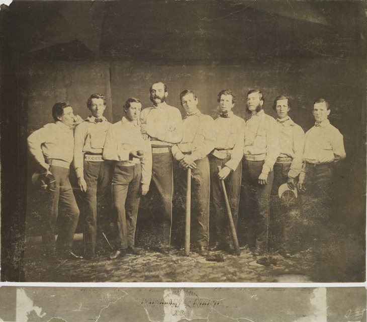 Baseball history photo: Brooklyn Excelsiors 1860 (left to right): Thomas Reynolds, SS; James Whiting, 3B; Jim Creighton (holding ball), P; Henry D. Polhemus, 2B; Aleck T. Pearsall, 1B; Edwin Russell, LF; Joe Leggett, C; Asa Brainard, LF; and George Flanly, CF. When the Civil War began 91 members of the Excelsior Club volunteered, although none of the first nine.  In the winter 1862 Aleck T. Pearsall, who was a physician, volunteered for the Confederates.  He became a Brigade Surgeon in Richmond, Virginia and even attended to some Union prisoners and even members of the Excelsior Club.  When this information reached Brooklyn, the Excelsior Club expelled him.  Click photo to return to previous page.