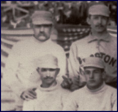 Detail from 1886 Boston/New York team photo. The only pitcher in the history of major league baseball to win 60 games in a single season, Charles “Old Hoss” Radbourn extends his middle finger towards the camera. Click to enlarge.